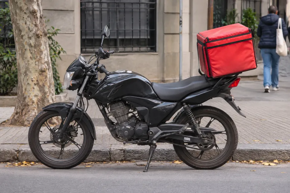Moto de reparto con caja térmica en una calle